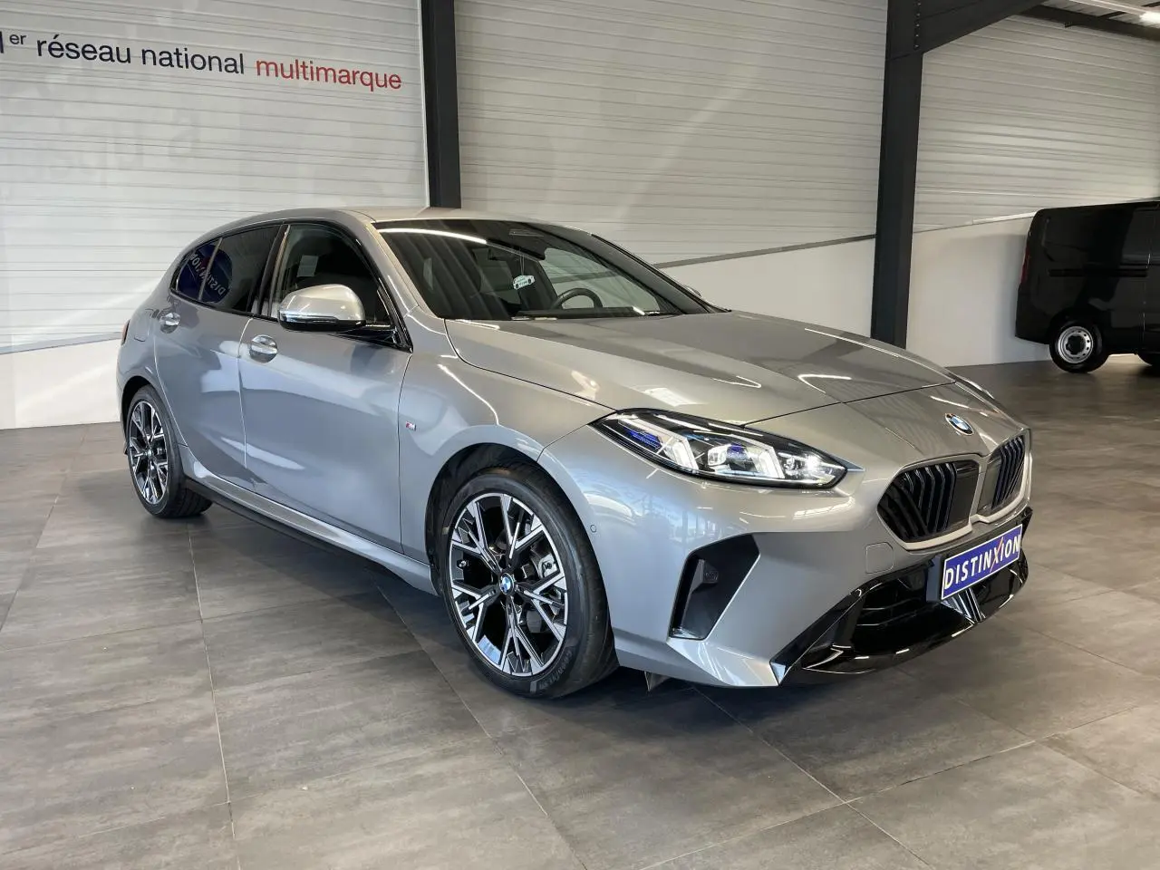 BMW Série 1 120d M Sport gris vue 3/4 avant droit, avec calandre noire et jantes alliage distinctives.
