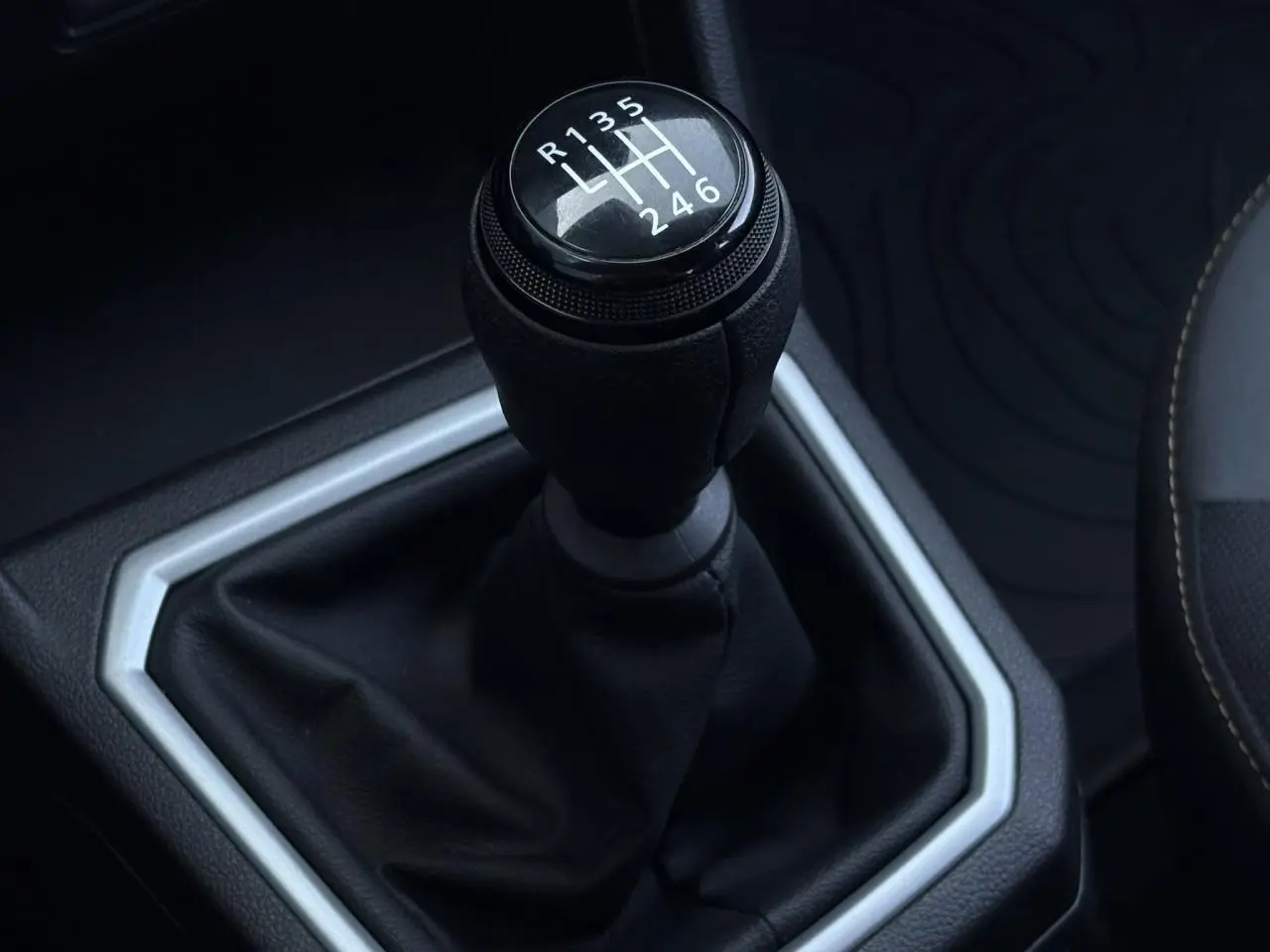 Gros plan sur le levier de vitesses manuel noir de la Dacia Sandero Stepway 2025, intérieur avec coutures contrastées.