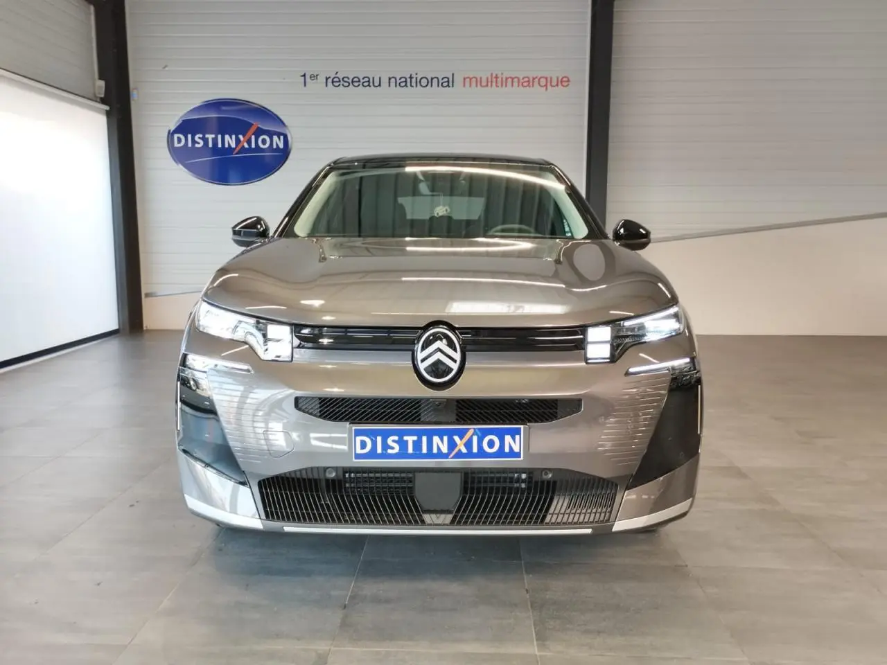 Vue frontale d'une Citroën C5 Aircross gris platine 2026 avec calandre noire brillante et logo central distinctif.