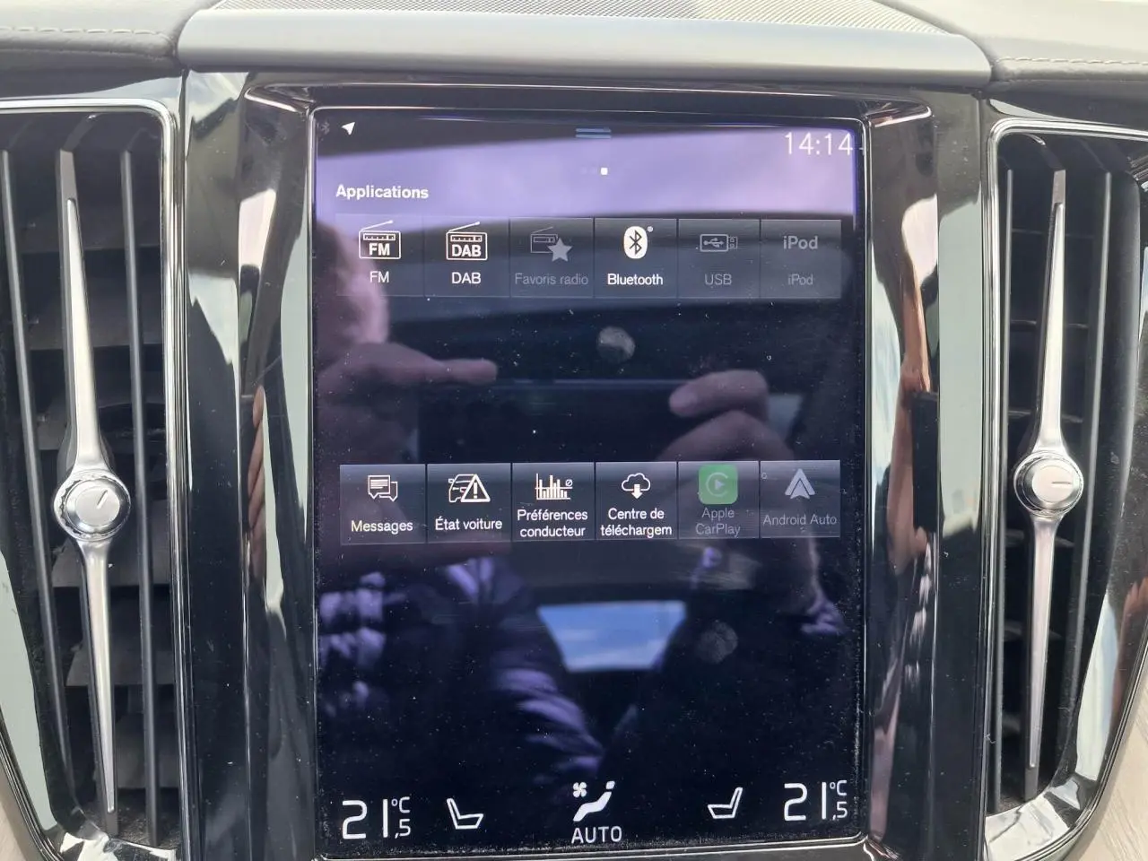 Écran tactile central du tableau de bord du Volvo XC60 noir, affichant les options multimédia et climatisation.