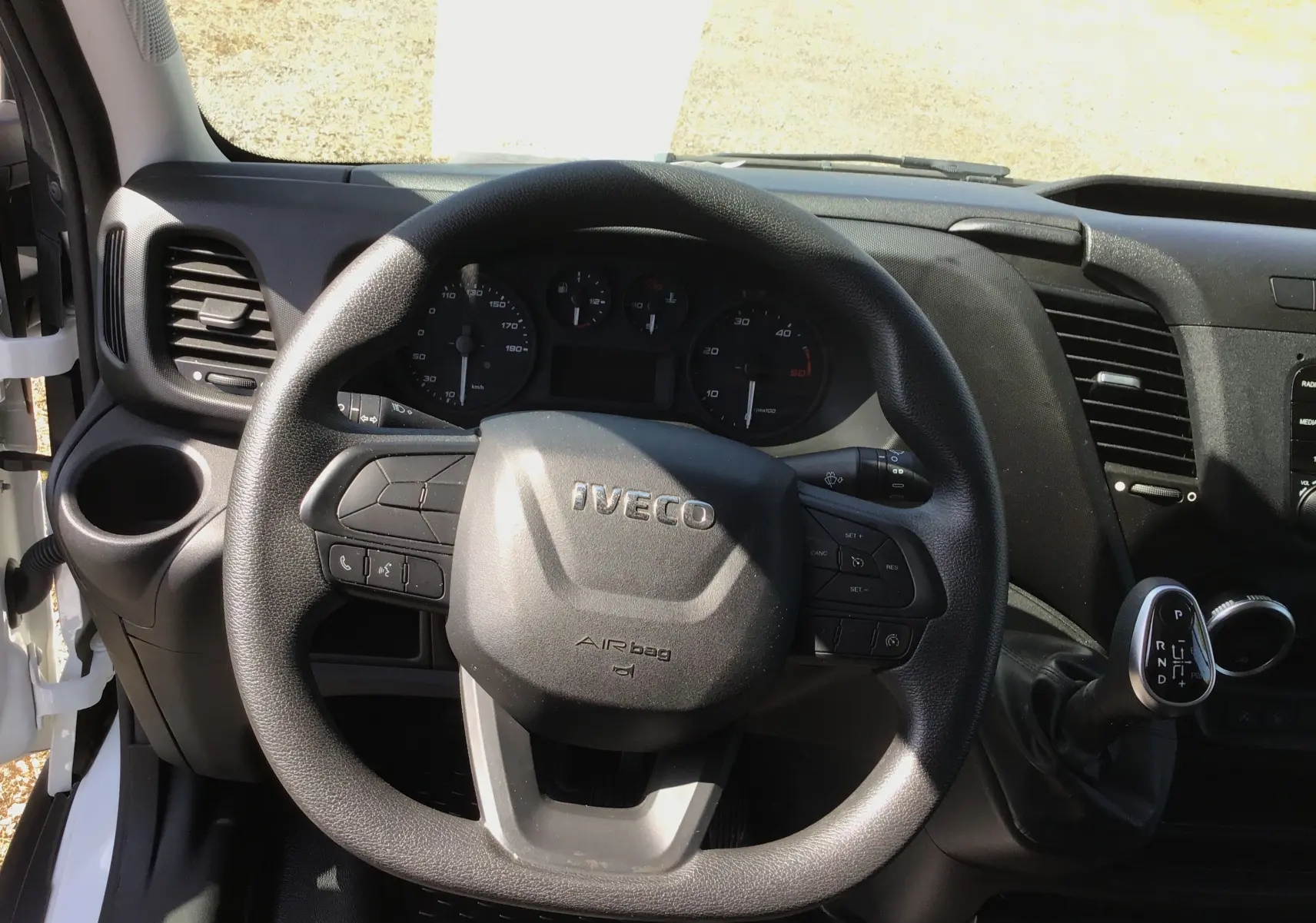 Vue rapprochée du volant noir IVECO et du tableau de bord du fourgon blanc DAILY BVA 35S14 V12 HI-MATIC 2022.
