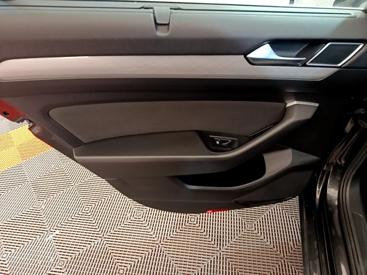Panneau de porte intérieur côté gauche gris foncé de la Volkswagen Passat 2.0 TDI 2021 avec poignée intégrée et finition sobre.