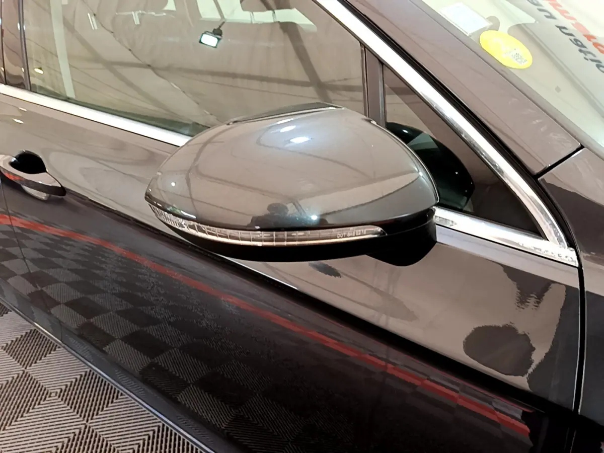 Rétroviseur droit gris foncé de la Volkswagen Passat 2021, avec clignotant intégré, vue rapprochée côté conducteur.