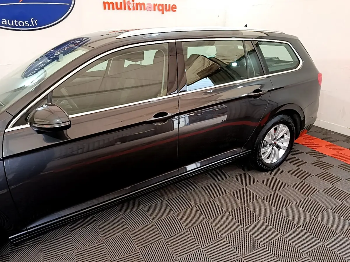 Profil côté gauche d'une Volkswagen Passat break gris foncé, avec jantes alliage et rétroviseurs électriques.