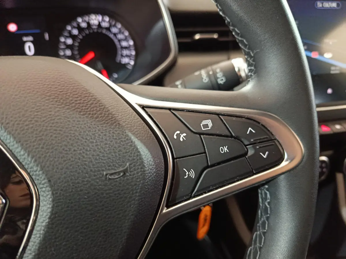Gros plan sur le volant cuir noir de la Renault Clio Business TCe 90 avec commandes multifonctions à droite.