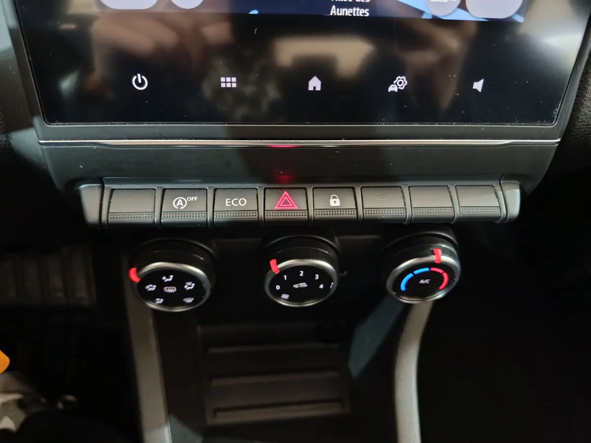 Gros plan sur la console centrale de la Renault Clio Business TCe 90 2021, montrant les commandes de climatisation et boutons fonctionnels.