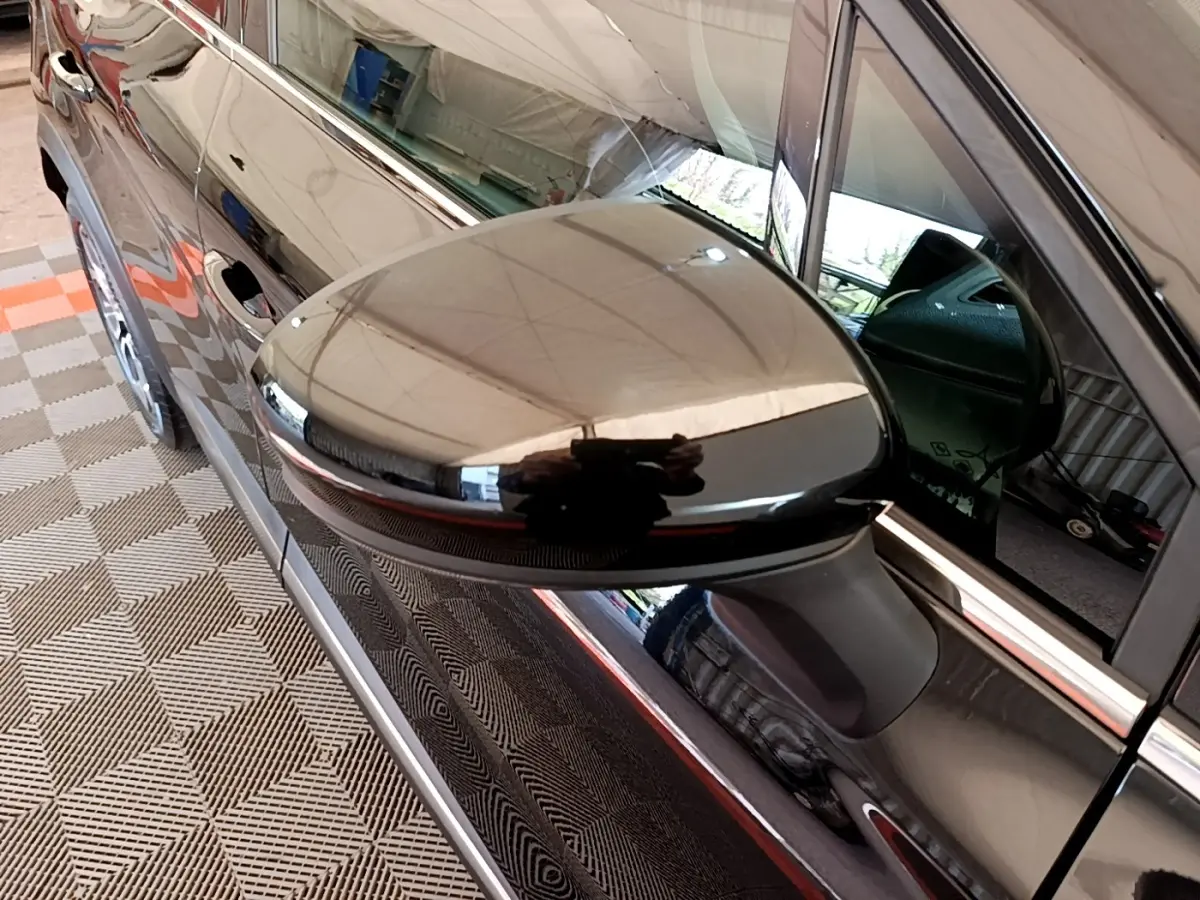 Gros plan sur le rétroviseur noir côté conducteur du Renault Captur Business Blue dCi 115 EDC 2021, reflet brillant.