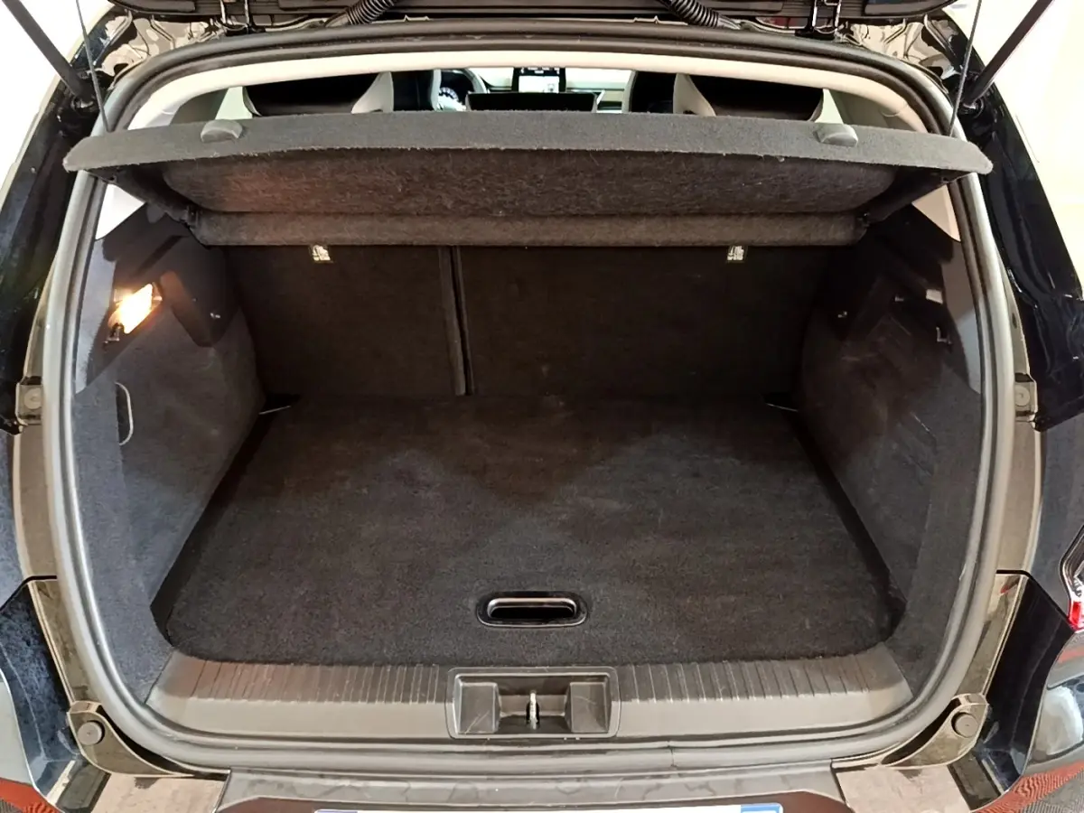 Coffre ouvert vu de l'arrière d'un Renault Captur Business noir, montrant un espace de chargement propre et spacieux.