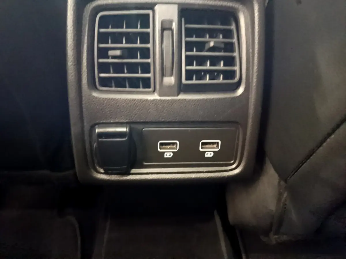 Détail intérieur montrant la prise 12V et deux ports USB sous les aérateurs arrière du Renault Captur noir Business 2021.
