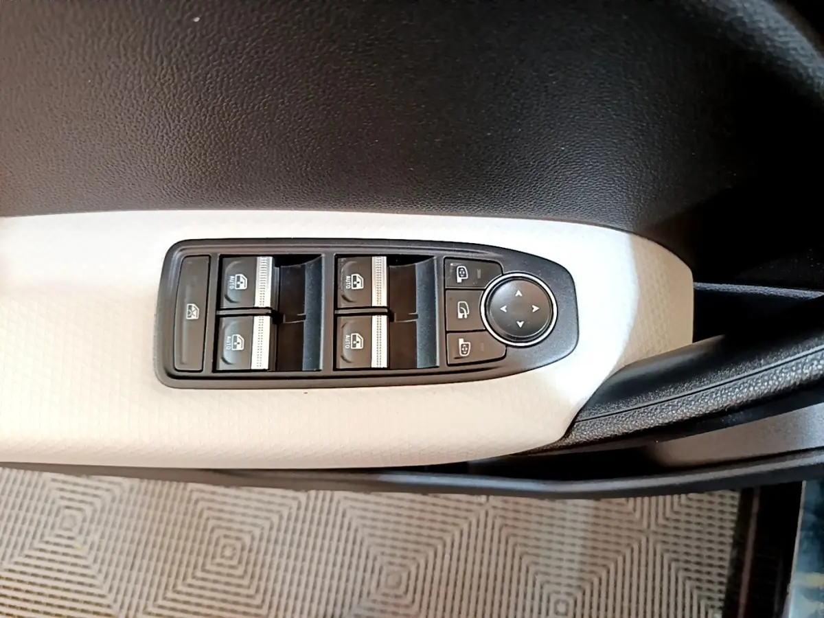 Gros plan sur les commandes de lève-vitres et réglage des rétroviseurs sur la portière côté conducteur du Renault Captur noir.