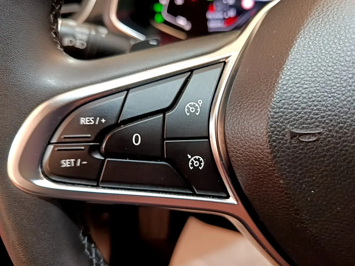 Gros plan sur les commandes noires du régulateur de vitesse à gauche du volant du Renault Captur Business 2021.