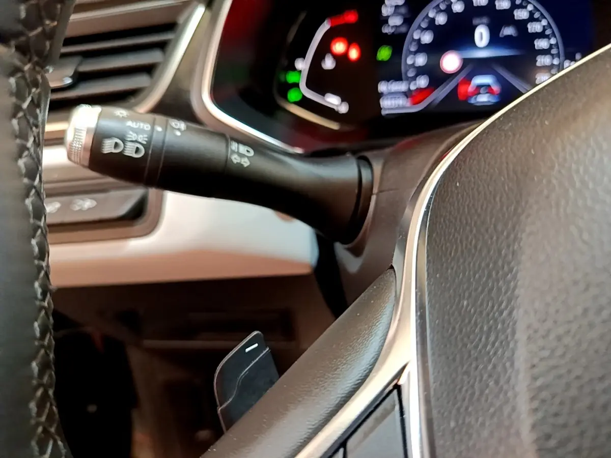 Gros plan sur le volant noir et la commande des phares du tableau de bord du Renault Captur Business 2021.