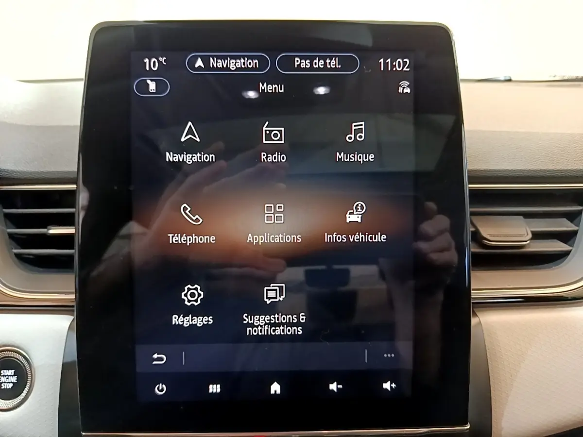 Écran tactile central du tableau de bord du Renault Captur Business noir, affichant le menu principal de navigation et multimédia.