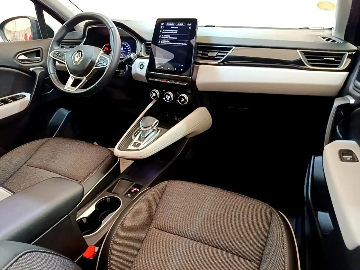 Vue intérieure avant droite du Renault Captur Business 2021, tableau de bord clair avec écran tactile vertical et sièges gris.