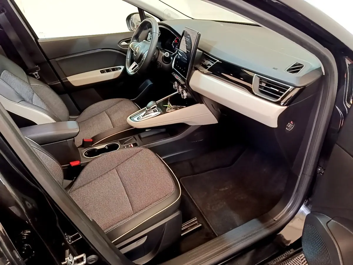 Vue intérieure côté passager du Renault Captur Business noir, avec tableau de bord beige et écran tactile vertical.