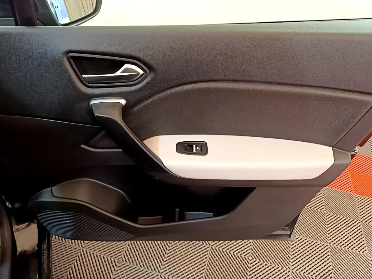 Vue intérieure du panneau de porte avant gauche du Renault Captur Business noir, avec insert blanc et commande de vitre électrique.