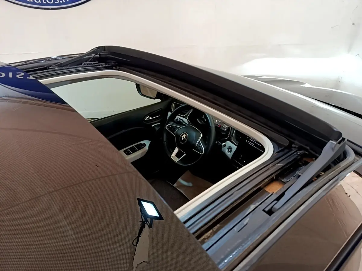 Vue plongeante sur l'intérieur noir du Renault Captur Business 2021, mettant en valeur le volant multifonctions et l'écran tactile.