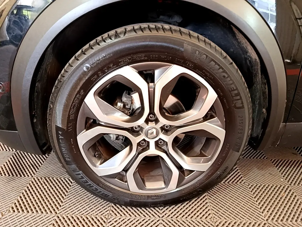 Gros plan sur la roue avant gauche du Renault Captur noir, mettant en valeur la jante alliage et le pneu Michelin.
