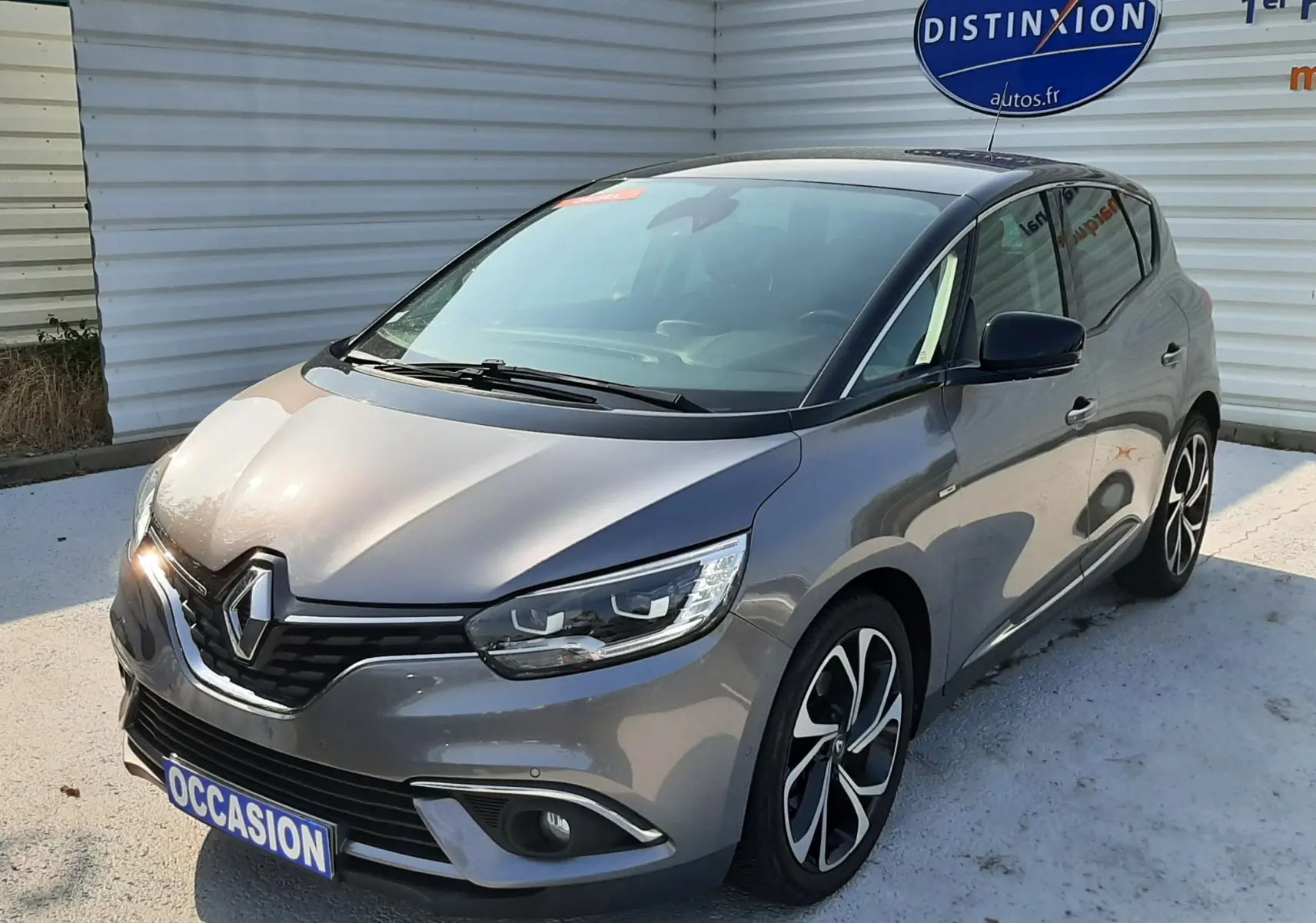 Renault Scénic IV gris Cassiopée avec toit noir, vue 3/4 avant droit, jantes alliage et calandre chromée.