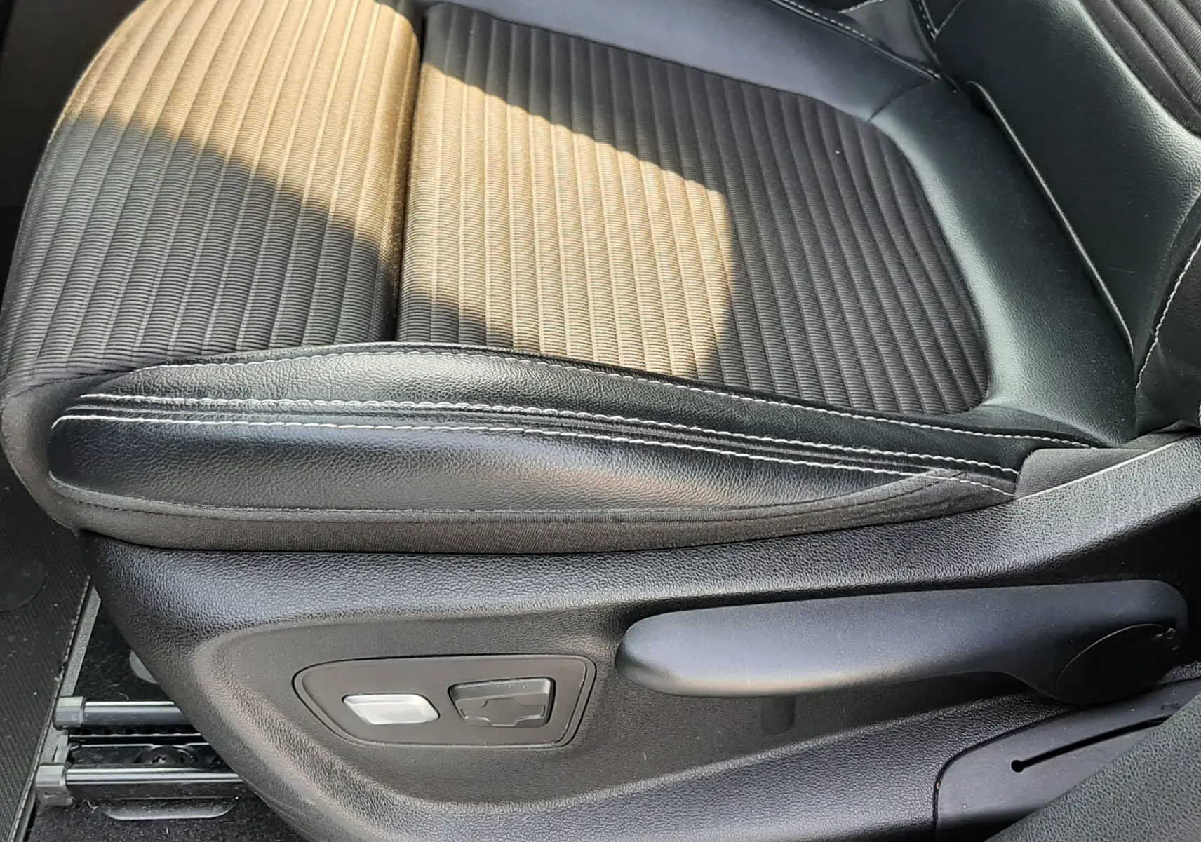 Gros plan sur le siège avant droit en cuir et tissu noir du Renault Scénic IV 2018, avec commandes électriques visibles.