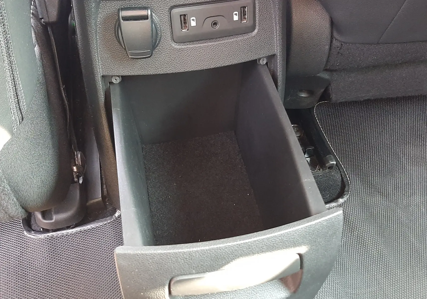 Tiroir de rangement ouvert à l'arrière d'une Renault Scenic IV 2018, avec prises USB et prise 12V visibles.