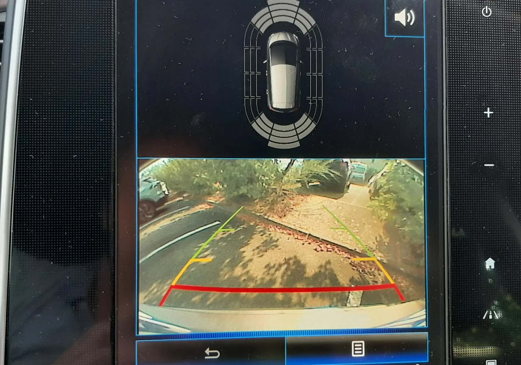 Écran de caméra de recul et capteurs de stationnement du Renault Scénic IV gris Cassiopée avec toit noir, vue arrière du véhicule.