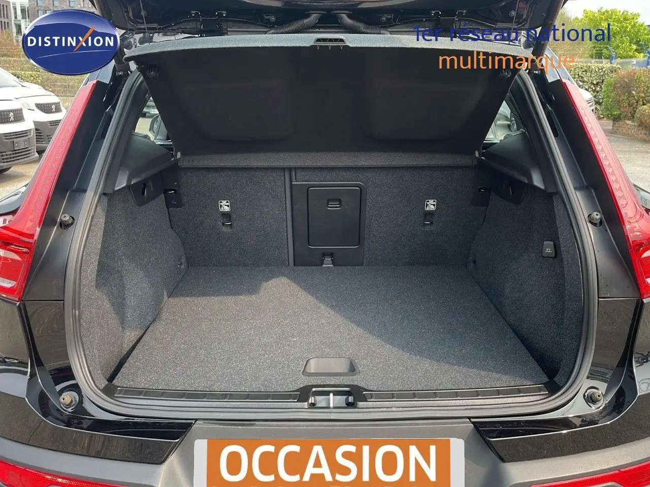 Coffre ouvert d'un Volvo XC40 noir Onyx Metal vu de l'arrière, montrant l'espace de chargement vide et la finition intérieure grise.