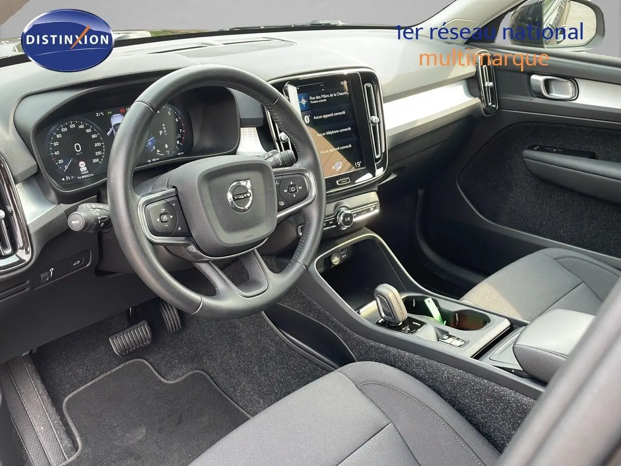 Intérieur du Volvo XC40 noir Onyx Metal, vue côté conducteur sur le volant, tableau de bord et console centrale moderne.