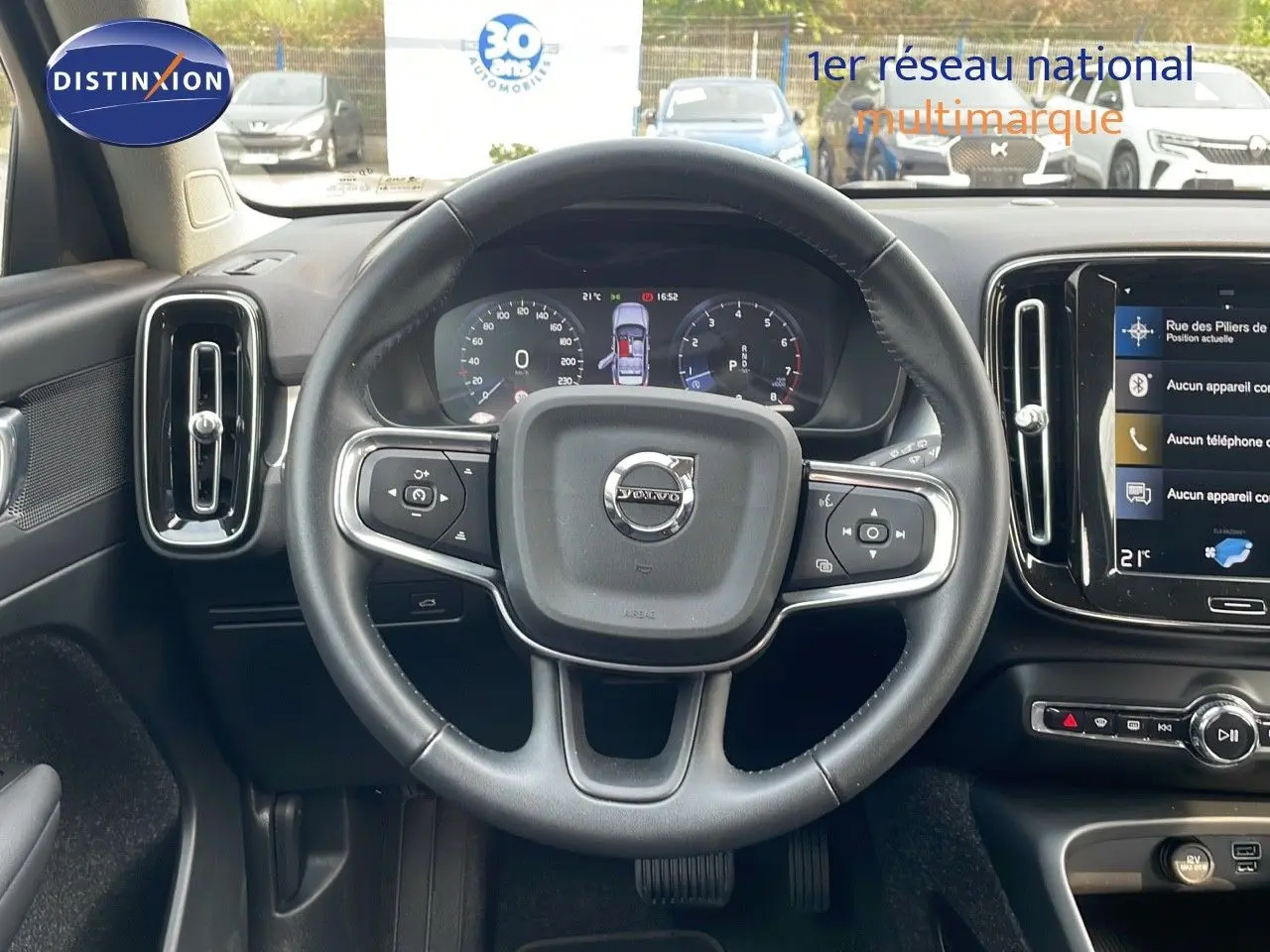 Vue intérieure centrée sur le volant du Volvo XC40 noir Onyx Metal, avec tableau de bord numérique et écran tactile.