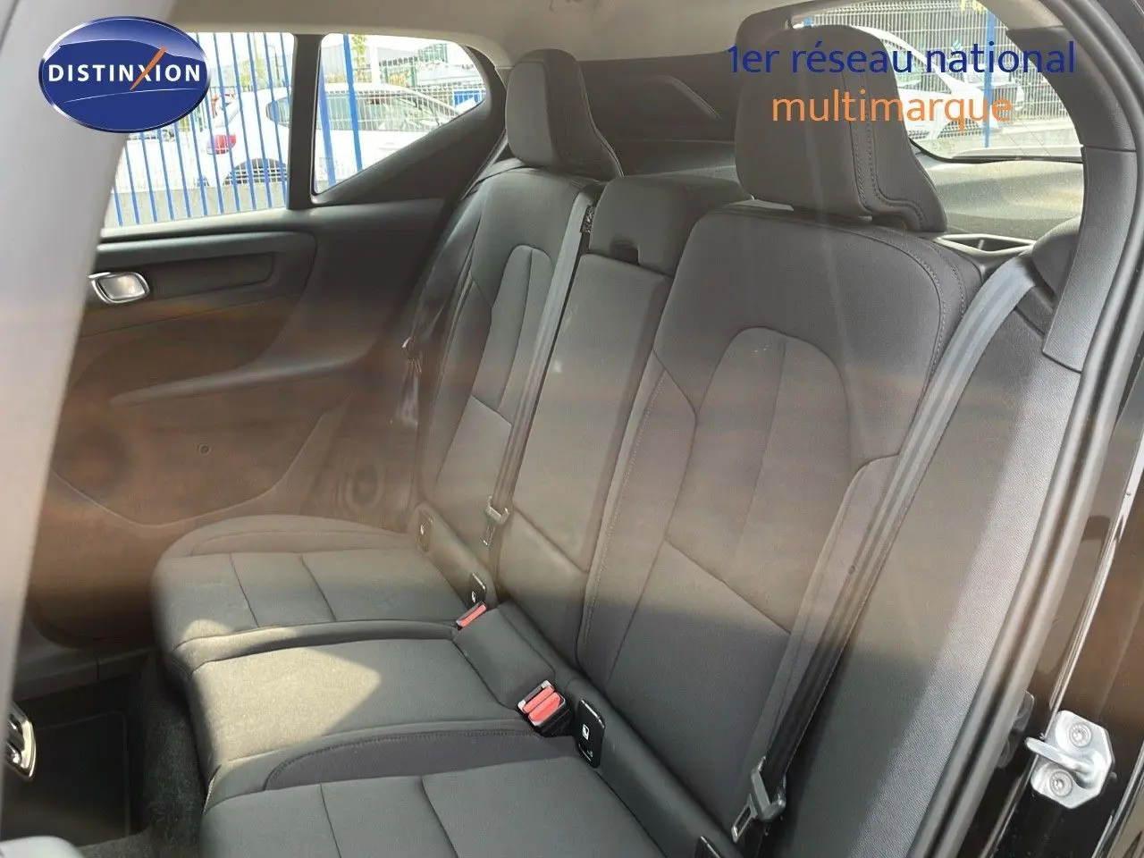 Vue intérieure du siège arrière côté droit du Volvo XC40 noir Onyx Metal, montrant les ceintures et appuie-têtes.