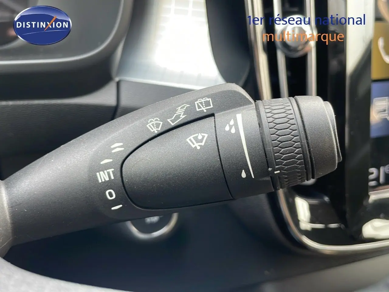 Gros plan sur la manette d'essuie-glace du Volvo XC40 noir Onyx, avec commandes et symboles visibles.