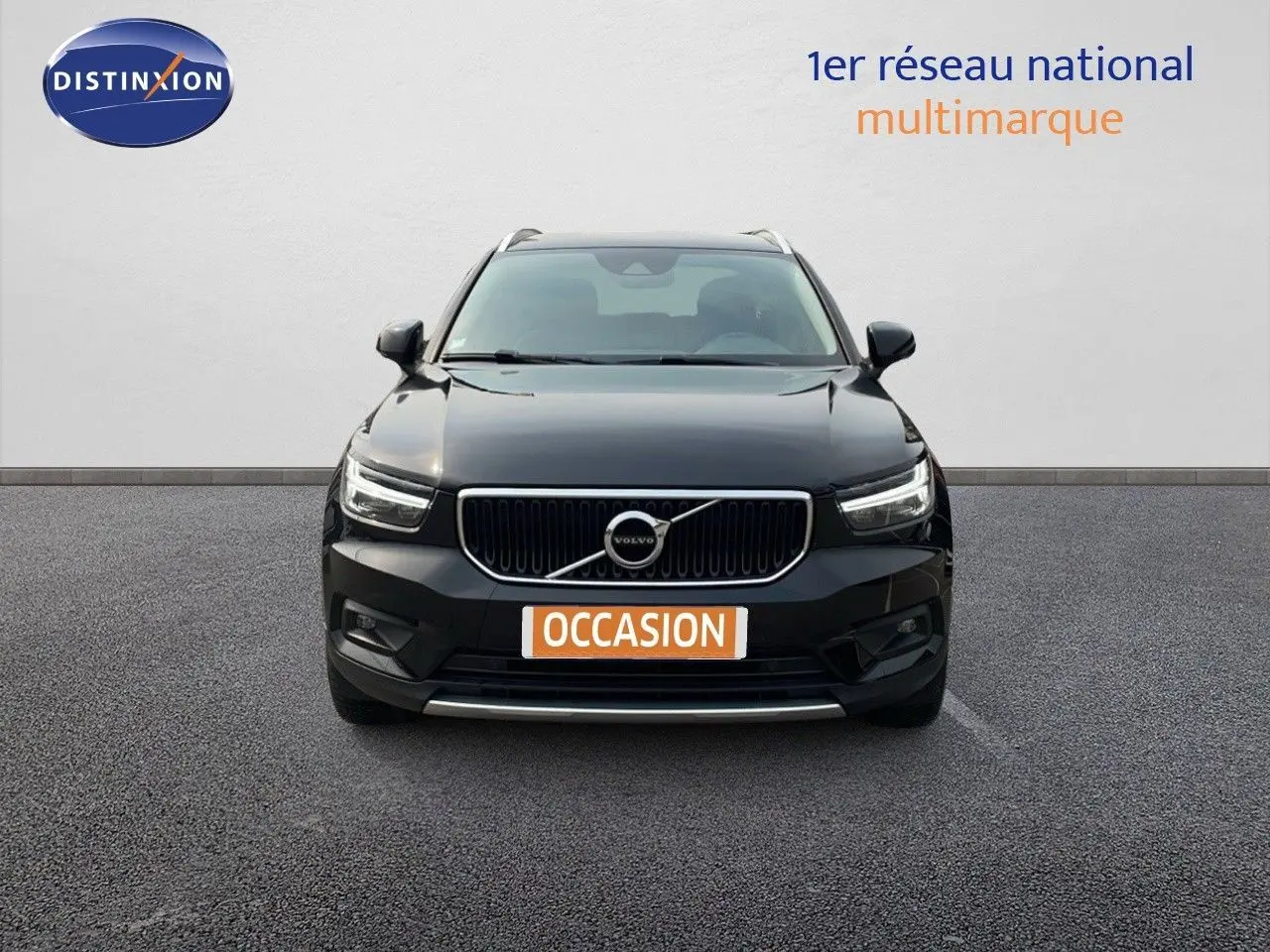 Vue frontale d'un Volvo XC40 noir Onyx Metal avec calandre chromée et phares LED allumés.