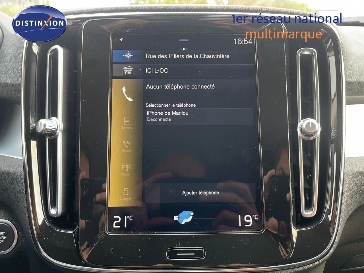 Écran tactile central du tableau de bord du Volvo XC40 noir Onyx Metal, affichant les réglages de téléphone et climatisation.