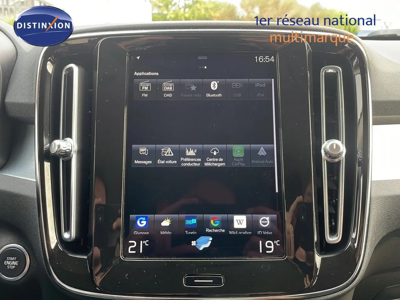 Vue rapprochée de l’écran tactile central du Volvo XC40 noir Onyx Metal, affichant les applications multimédia et la climatisation.