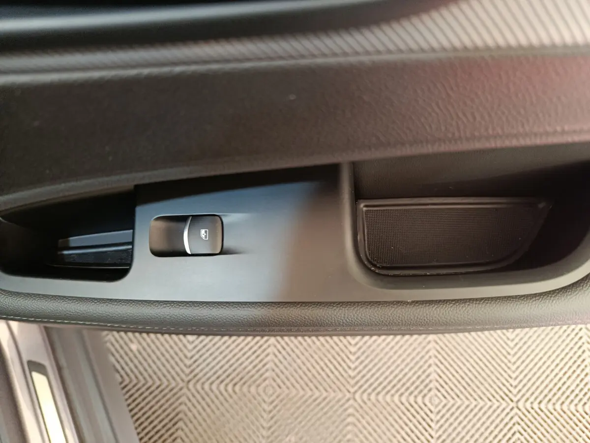 Gros plan sur la commande de lève-vitre côté conducteur de l'Alfa Romeo Stelvio gris foncé 2024.