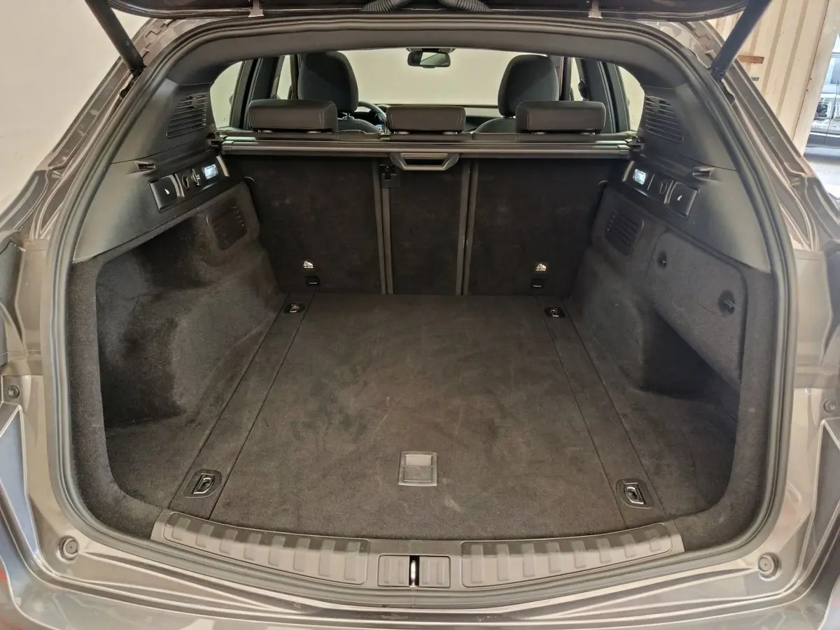 Coffre ouvert d'un Alfa Romeo Stelvio gris foncé 2024, vue arrière montrant l'espace de chargement et la banquette arrière.