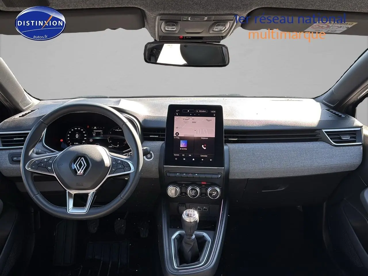 Tableau de bord et volant de la Renault Clio V gris pizzara avec écran tactile vertical et boîte manuelle visible.