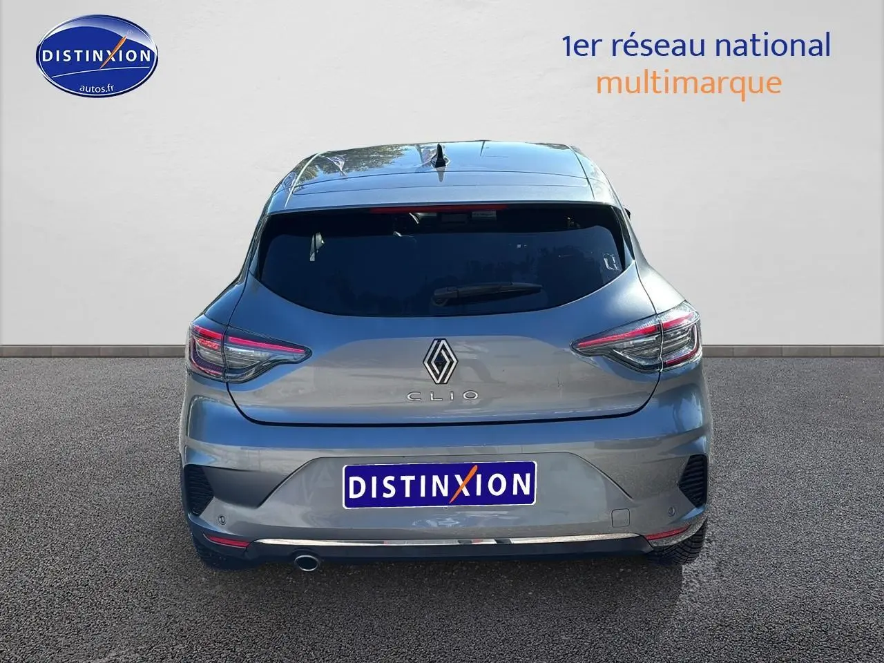 Vue arrière d'une Renault Clio V gris pizzara avec feux LED et pot d'échappement chromé visible.