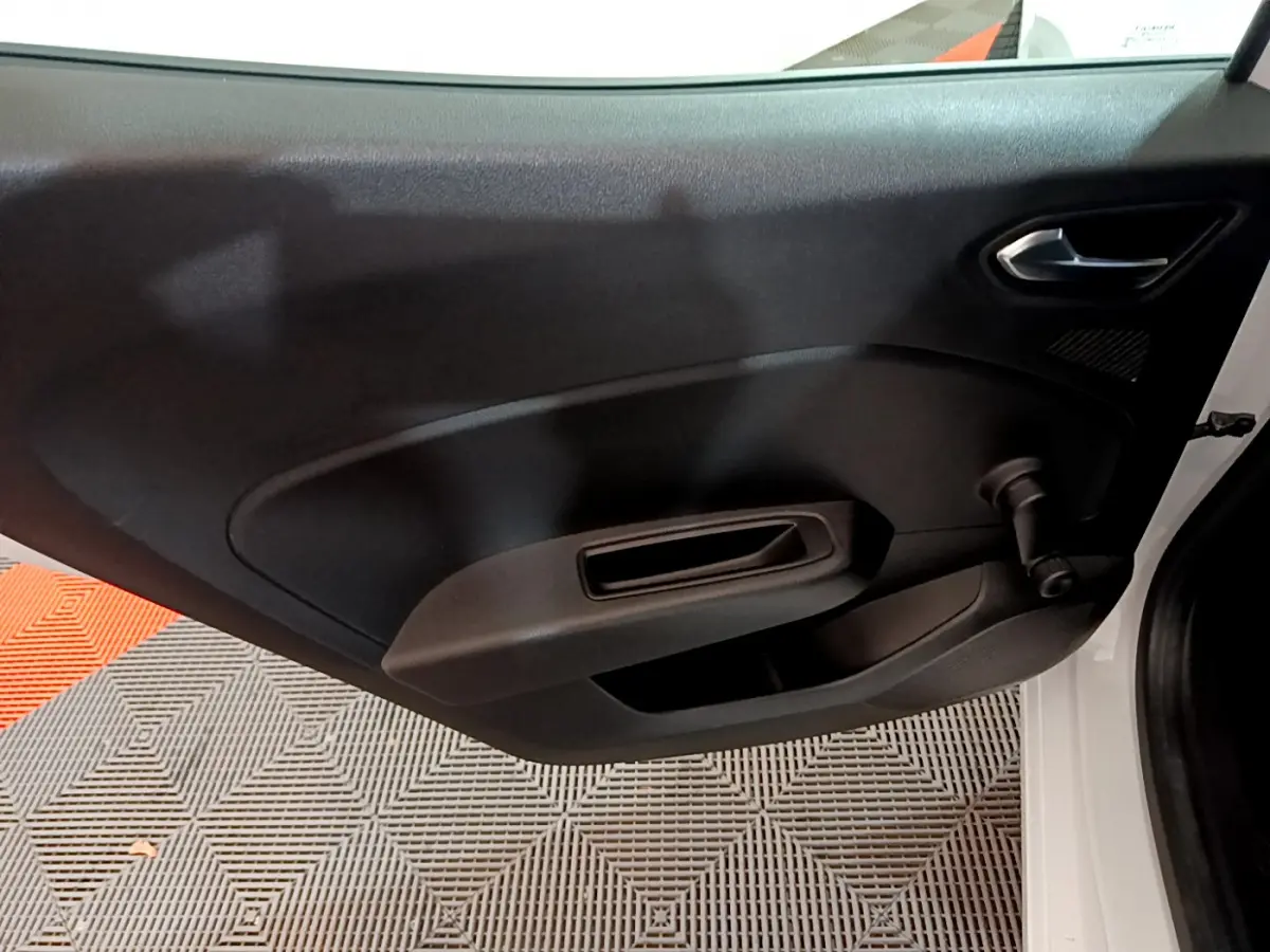 Vue rapprochée de la porte avant gauche noire de la Renault Clio Business TCe 90 blanche, avec poignée et manivelle de vitre.