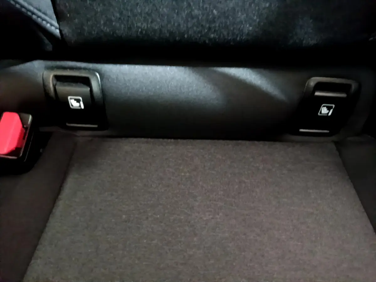 Détail de la banquette arrière noire de la Renault Clio Business TCe 90 avec boutons de rabattement des sièges visibles