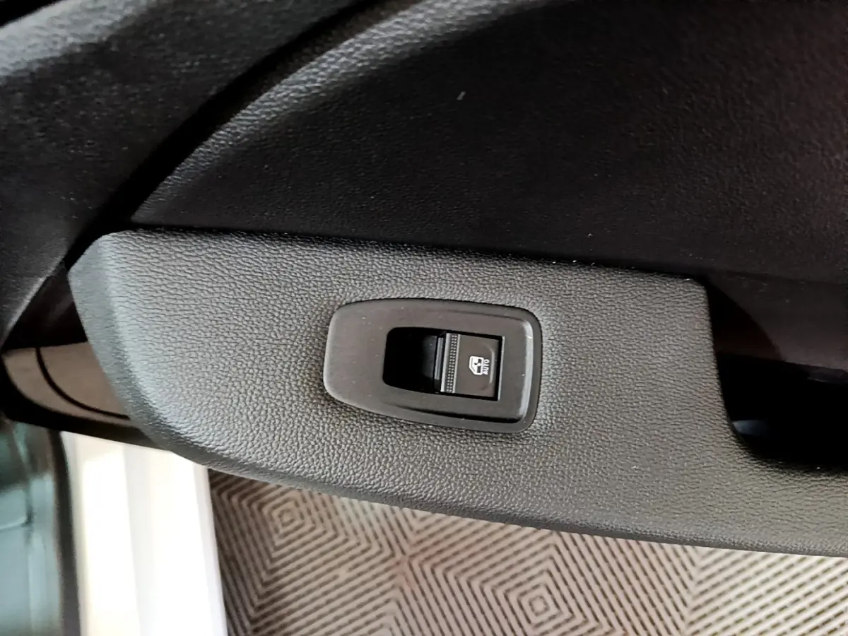 Gros plan sur le bouton de verrouillage électrique de la porte côté conducteur d'une Renault Clio blanche 2021.