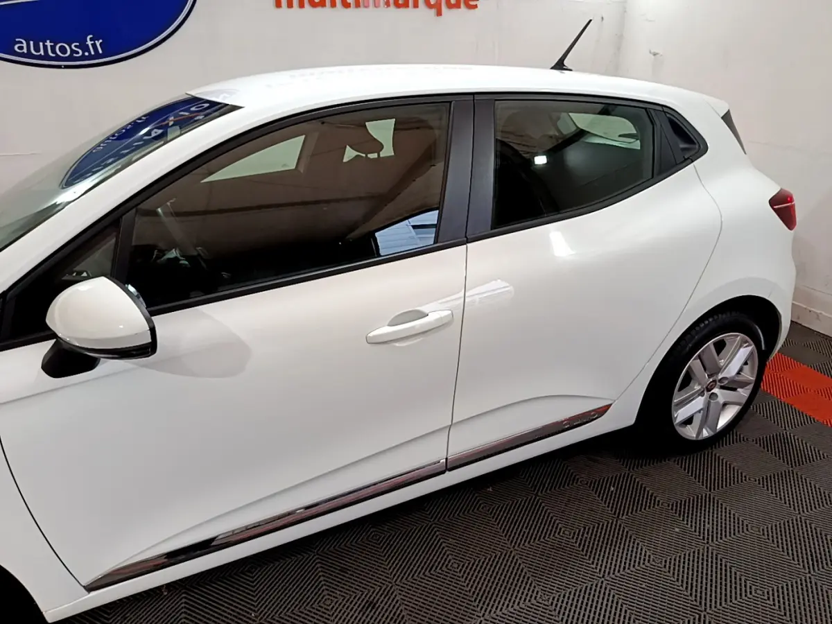 Profil côté gauche d'une Renault Clio Business TCe 90 blanche, avec jantes alliage et rétroviseur blanc.