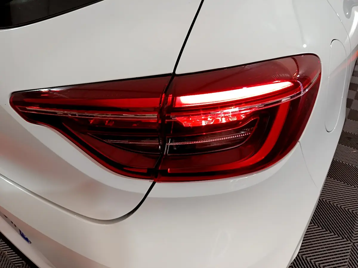 Feu arrière droit allumé de la Renault Clio Business TCe 90 blanche, vue rapprochée sur l'arrière du véhicule.