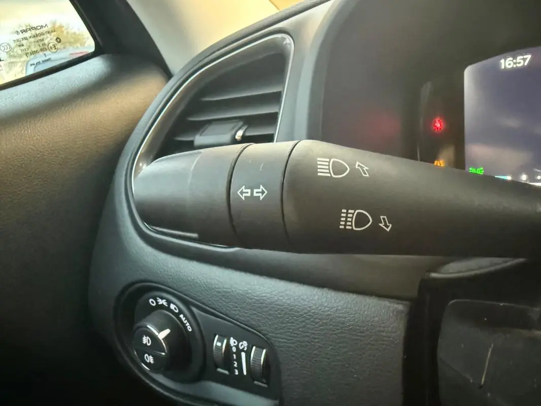 Détail du commodo d’éclairage et tableau de bord noir à l’intérieur du Jeep Renegade 2024, côté gauche.
