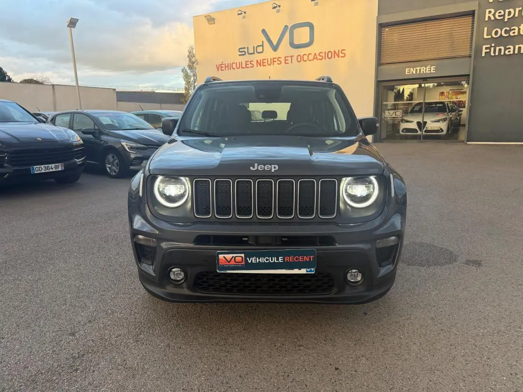 Vue de face d’un Jeep Renegade gris anthracite 2024 avec phares allumés et calandre distinctive à sept barres verticales.