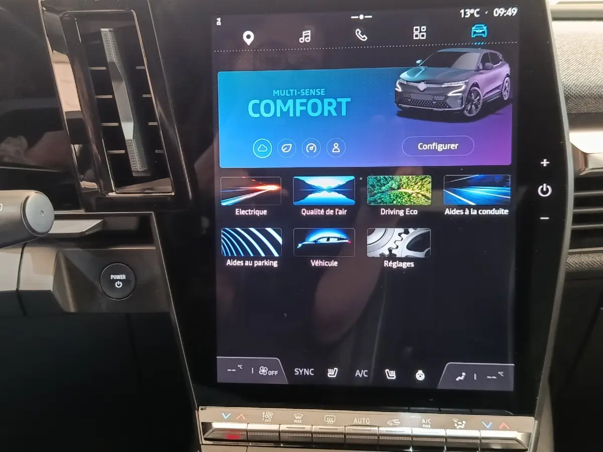 Vue rapprochée de l’écran tactile central affichant le menu multifonction d’une Renault Mégane Techno EV60 bleu.