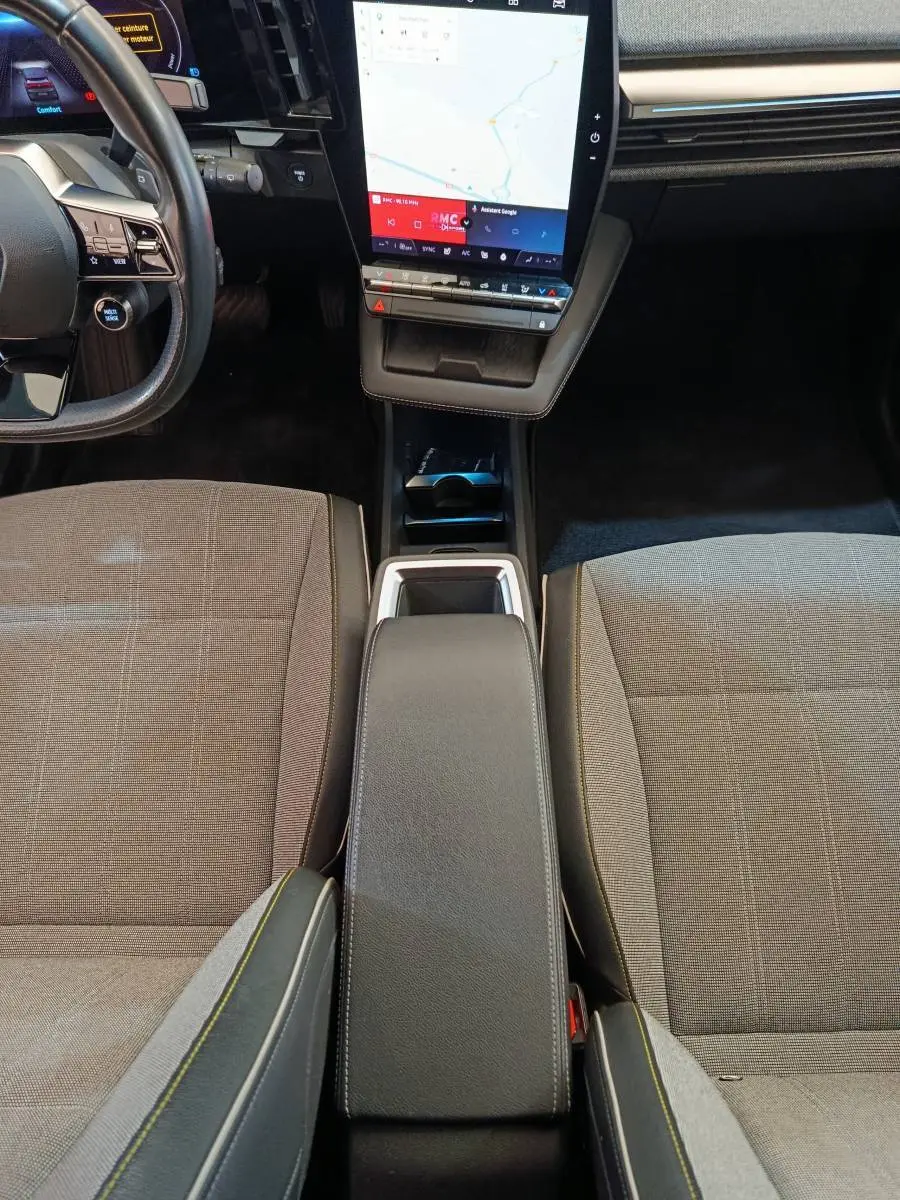 Vue intérieure centrée sur la console centrale et les sièges gris de la Renault Mégane Techno EV60 2023.