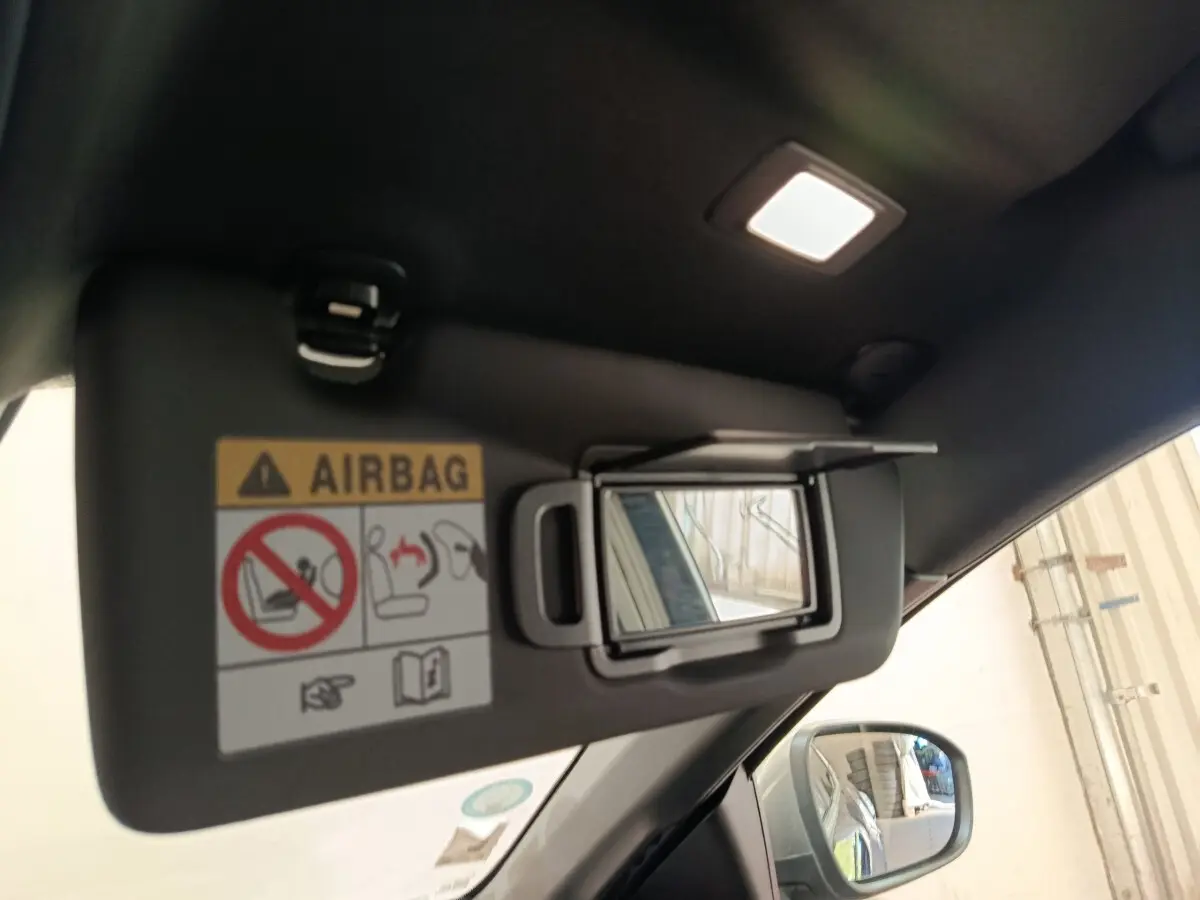 Miroir de courtoisie ouvert sur pare-soleil côté conducteur d'une Renault Mégane bleu, intérieur éclairé.