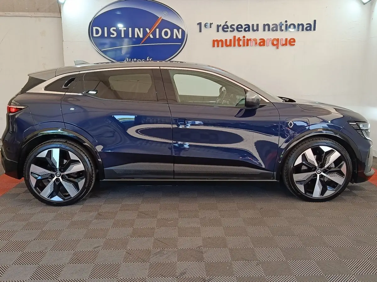 Profil droit d'une Renault Mégane Techno EV60 bleu électrique, avec jantes modernes et toit noir contrasté.