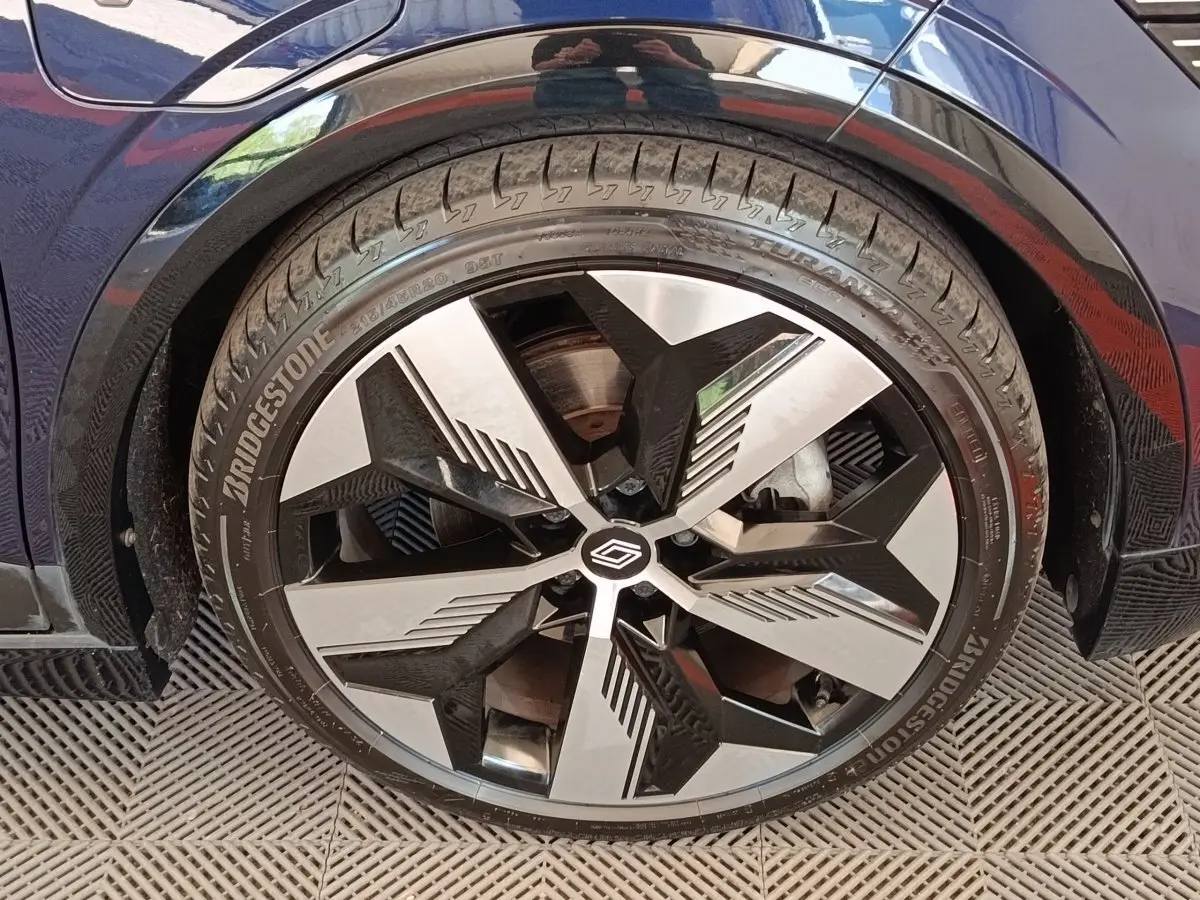 Gros plan sur la roue avant droite de la Renault Mégane Techno EV60 bleu, avec jante alliage au design moderne.
